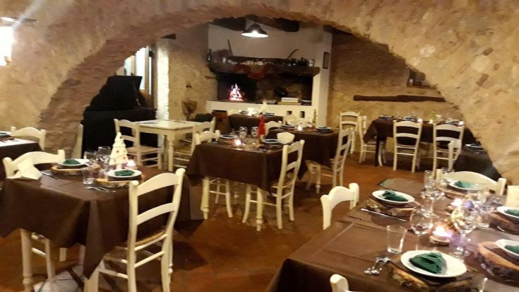 A cozy dining room with neatly arranged tables, featuring a rustic and welcoming atmosphere.