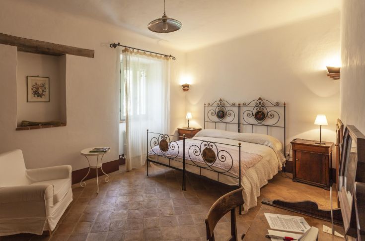 Comfortable room with wrought iron bed and warm colors creating a pleasant atmosphere.