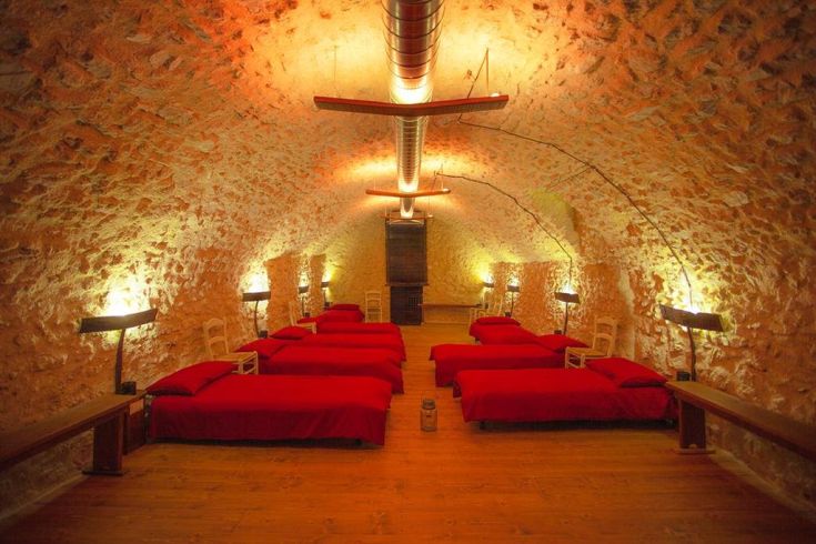 An underground space with red beds and warm lighting, perfect for a relaxed stay.