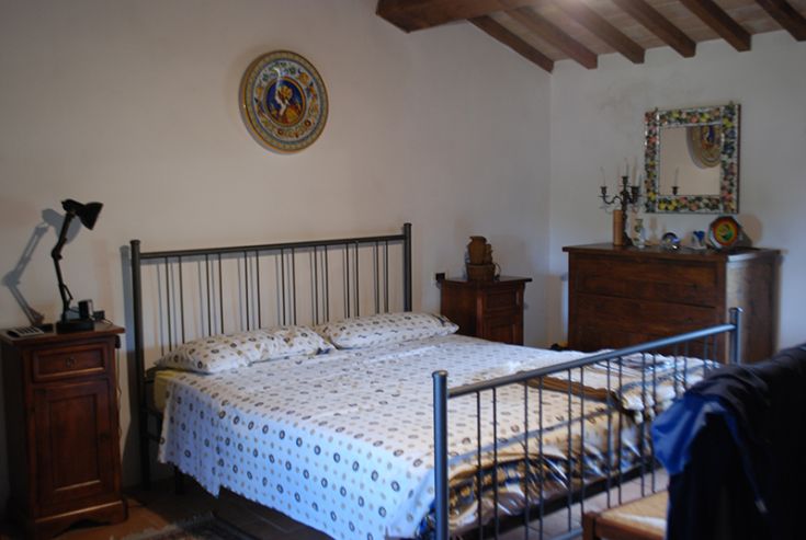 Chambre au design simple avec des meubles en bois et un lit double. Lumière naturelle et atmosphère paisible.