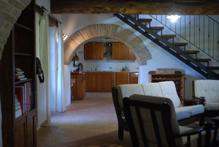 Intérieur d'un bâtiment rustique avec cuisine et salon, une ambiance chaleureuse et fonctionnelle.