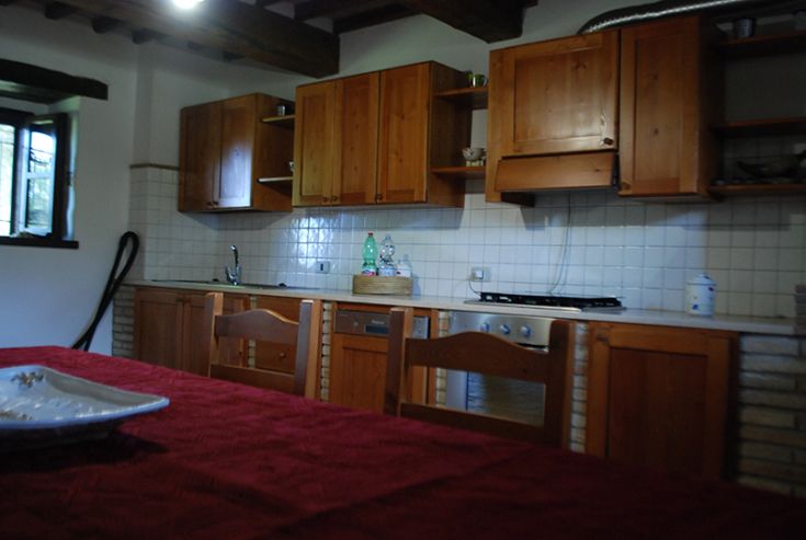 Cuisine simple avec des meubles en bois, ambiance chaleureuse et accueillante, idéale pour passer du temps ensemble.