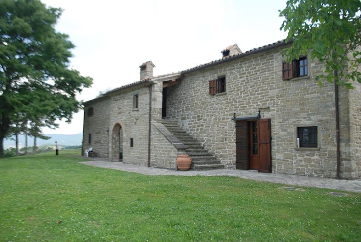 Un bâtiment en pierre dans un jardin spacieux, parfait pour des moments de détente en plein air.
