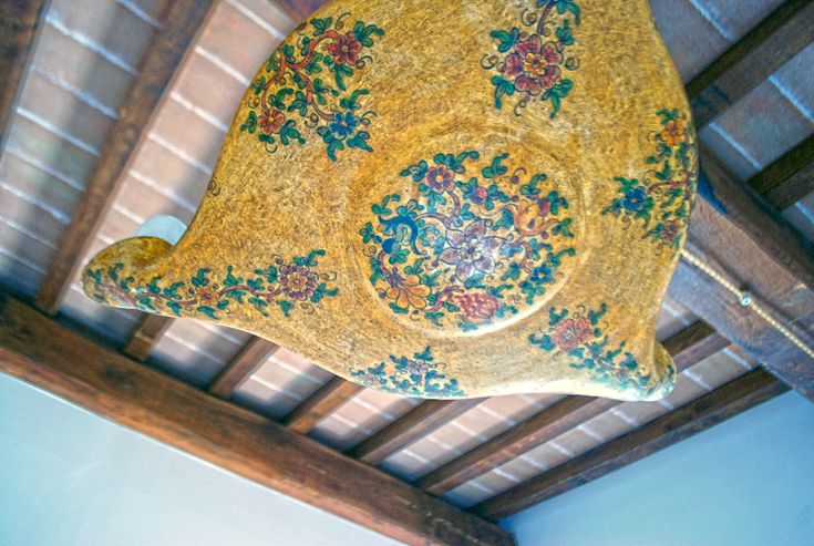 Décoration en bois avec des motifs floraux, située dans un environnement simple et accueillant.