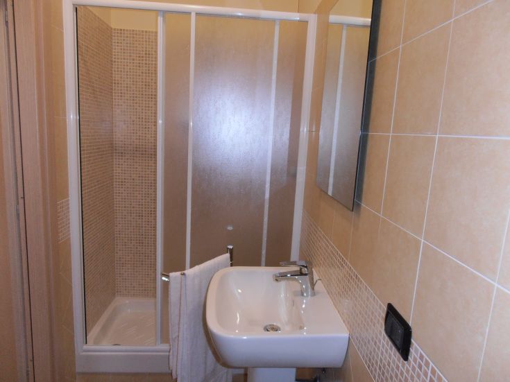 Bagno spazioso e ben illuminato, dotato di doccia e lavabo, perfetto per momenti di relax.