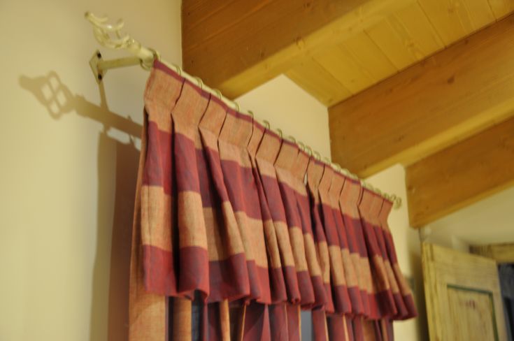 A red and beige striped curtain hanging on a wall, complemented by simple decorative elements.