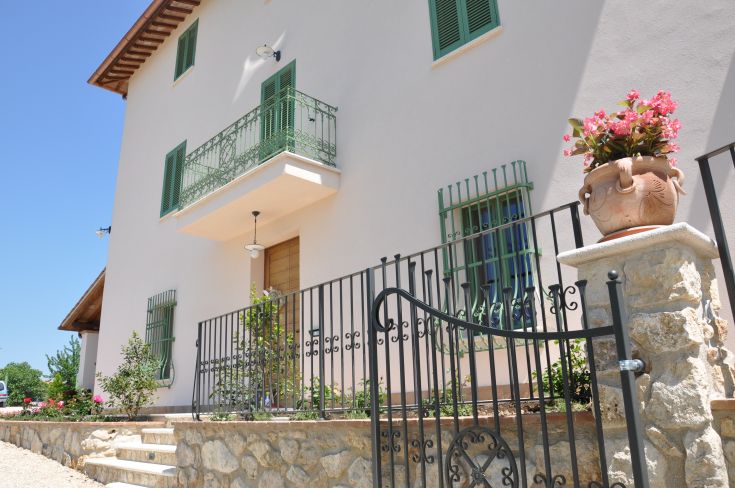 Detail of a house with a flowered balcony and a decorated entrance. Relaxing countryside atmosphere.