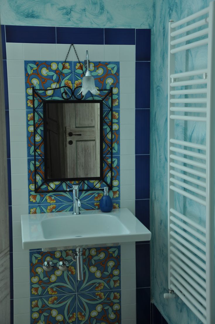 A contemporary bathroom featuring simple patterned tiles and a framed mirror. Practical and stylish elements.