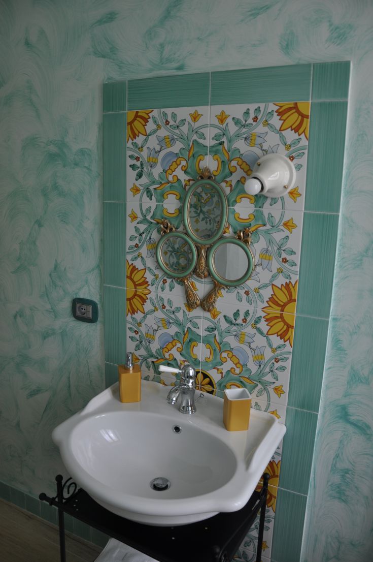 A modern bathroom featuring decorative tiles and a contemporary sink. A cozy and functional space.
