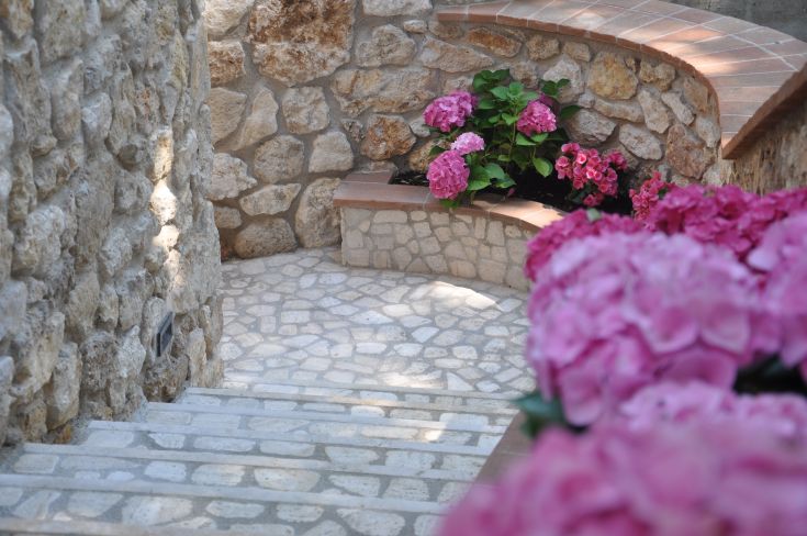 A stone path surrounded by pink flowers in a serene setting.