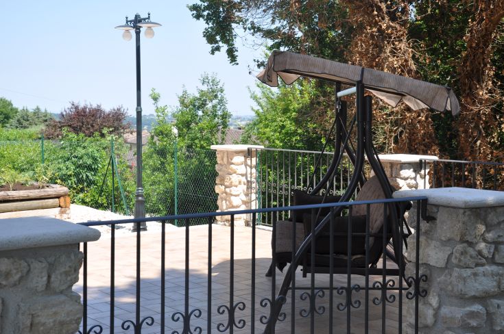 A peaceful outdoor corner with a rocking chair and a lush view of the Umbrian countryside.