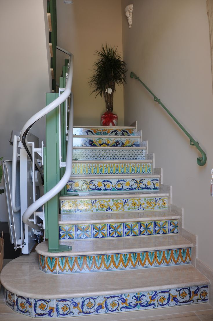A staircase adorned with colorful tiles leading to a cozy, well-lit area.