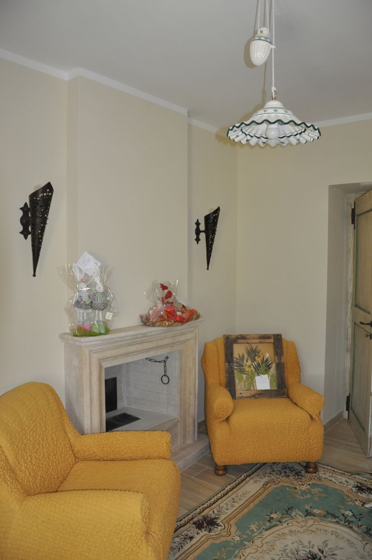 A simple living room with yellow armchairs and rustic decorations, perfect for relaxation.