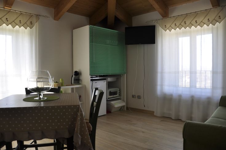 Spacious living room with modern furnishings and large windows, creating a bright atmosphere in a renovated building.