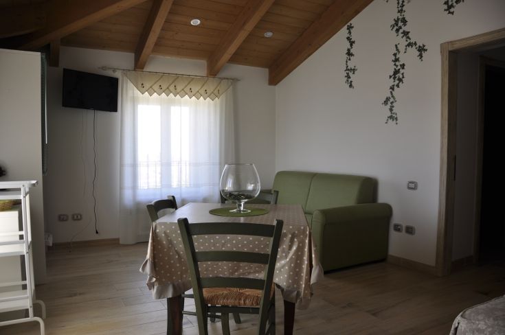 An interior space of a building featuring exposed beams and simple furnishings, perfect for relaxation.