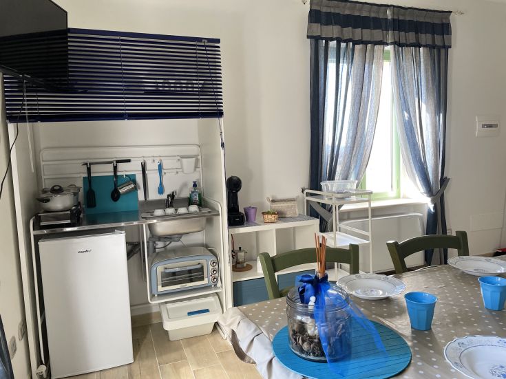 Well-lit kitchen and living area with contemporary furnishings and a cozy atmosphere.