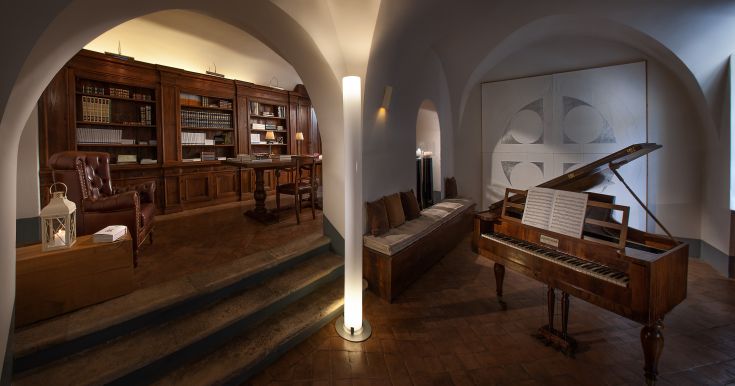 Simple interior with a piano and a wooden bookshelf, creating a relaxed and friendly atmosphere.