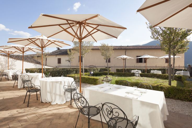 Outdoor restaurant with tables arranged outside, featuring umbrellas for comfortable sun protection.
