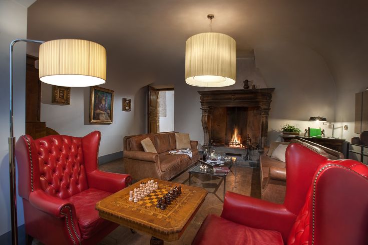 A comfortable classic-style living room with red armchairs and a fireplace for relaxing moments.