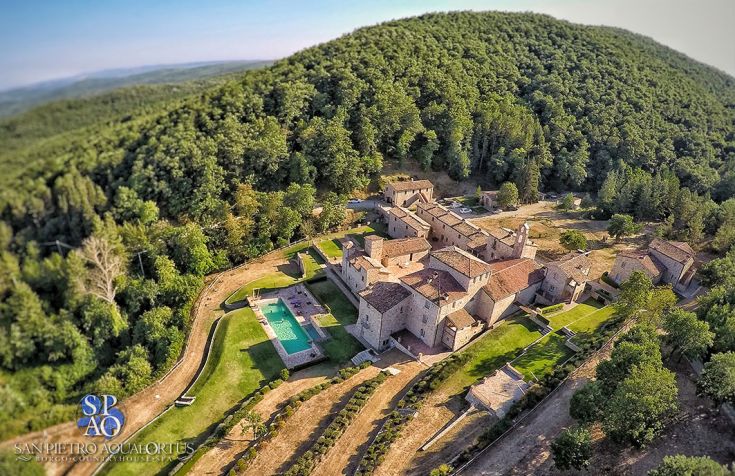 A picturesque medieval village surrounded by nature, featuring a pool and restaurant, perfect for relaxing moments.