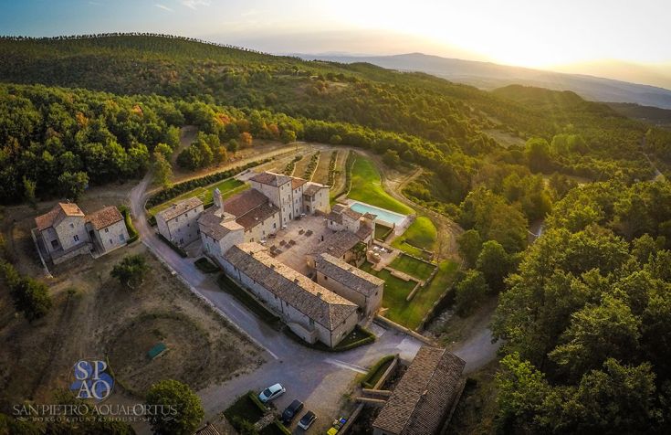 A tranquil medieval village surrounded by greenery, perfect for a cultural and relaxing visit.