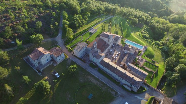 A renovated medieval village surrounded by nature, featuring stone buildings and welcoming outdoor spaces.