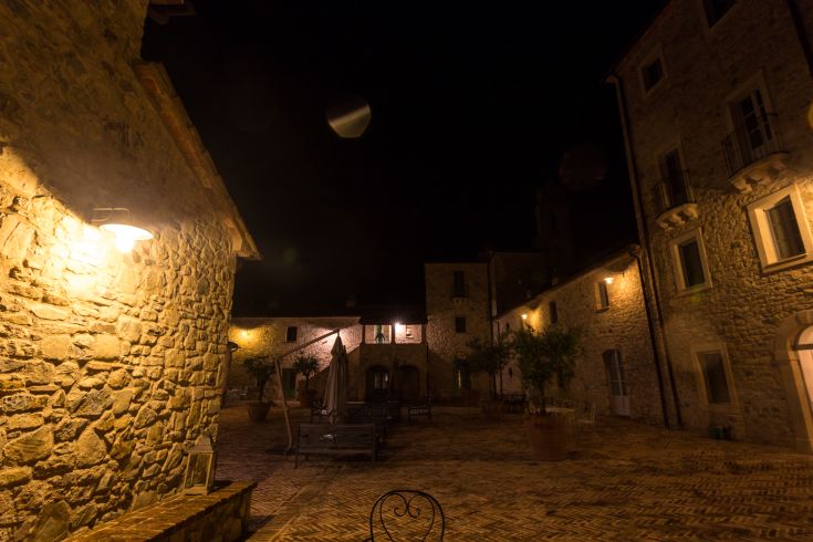 A medieval village illuminated at night, showcasing distinct architectural details in a serene atmosphere.