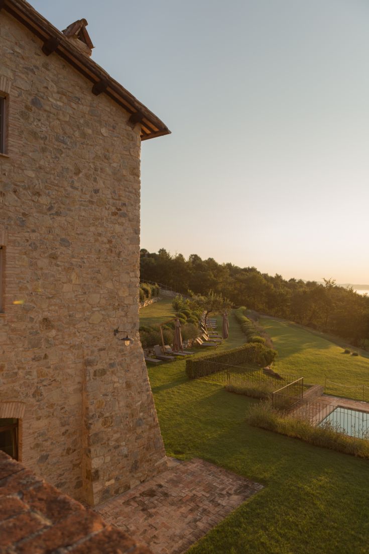 A serene historic village surrounded by nature, featuring a pool for relaxation.