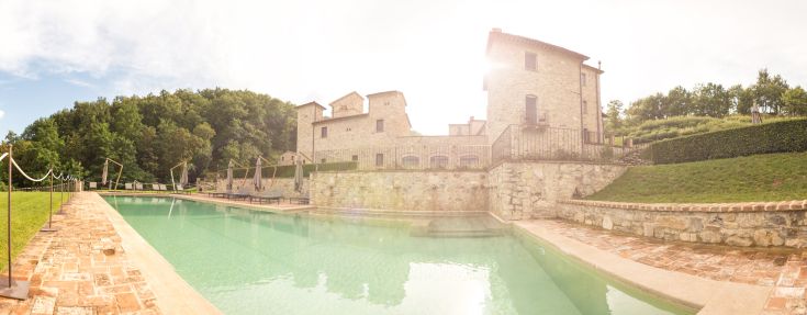 A villa surrounded by greenery, featuring a pool and elegant rooms, perfect for a peaceful stay.