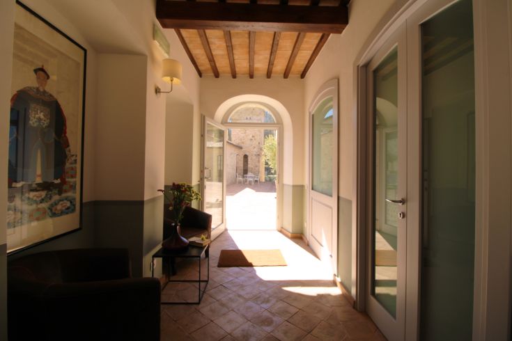 A spacious house entrance that opens to an outdoor area, utilizing natural light.