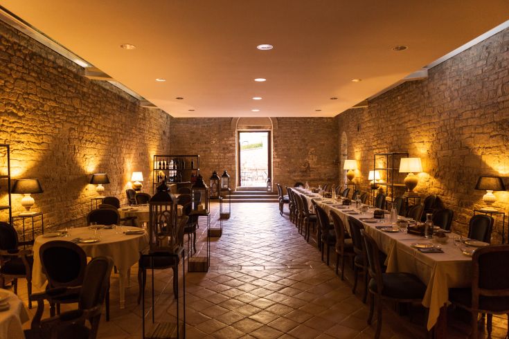 A serene atmosphere in a restaurant featuring stone walls and soft lighting, ideal for peaceful moments.