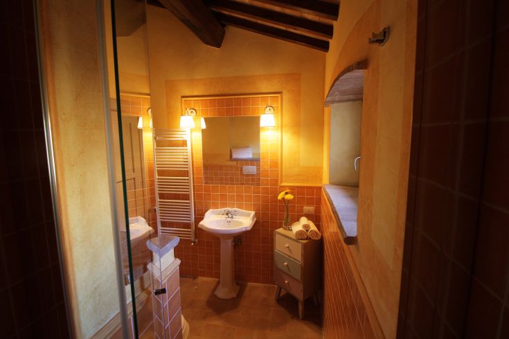 Bright bathroom with colorful tiles, warm lighting, and functional furnishings.