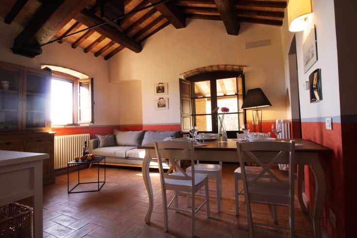 Cozy living room with exposed beams and natural light, a perfect corner for relaxing moments.