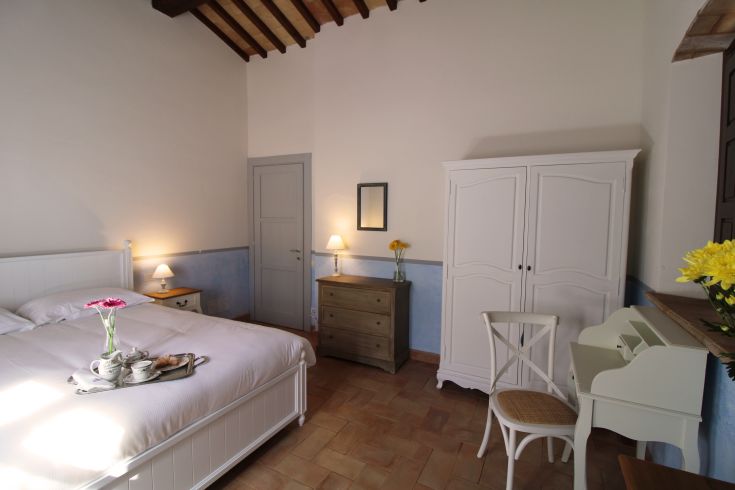 Comfortable room with a double bed, simple decor, and a tray with breakfast ready to serve.