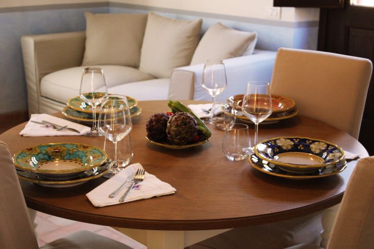 The table is set with simple dishes and glassware, ready to welcome guests.