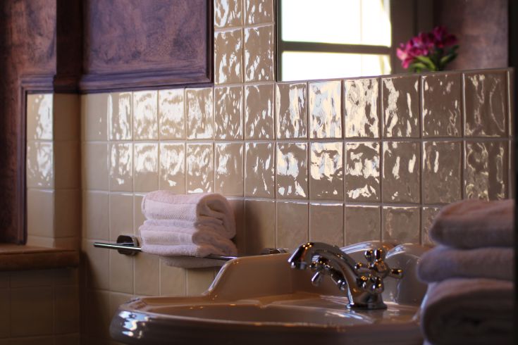 An elegantly furnished bathroom with shiny ceramics and neatly arranged towels, perfect for relaxation.