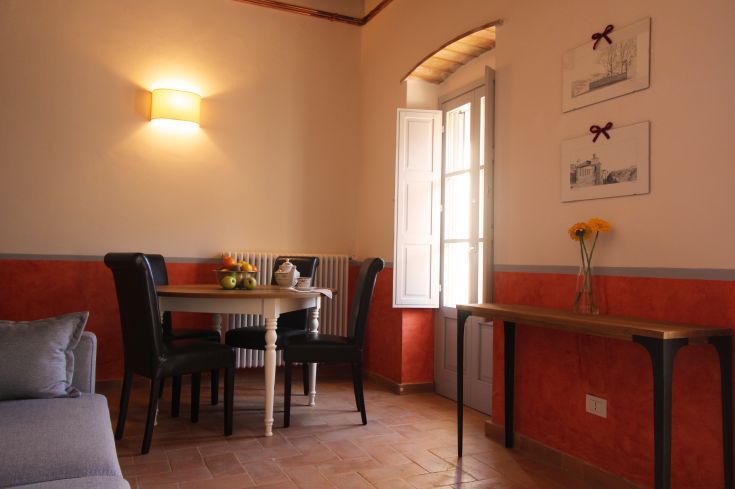 A simple living room with a table and windows allowing light in, a space perfect for relaxation.