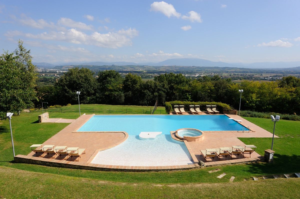 Une piscine tranquille entourée de collines vertes ombriennes, idéale pour des moments de détente.