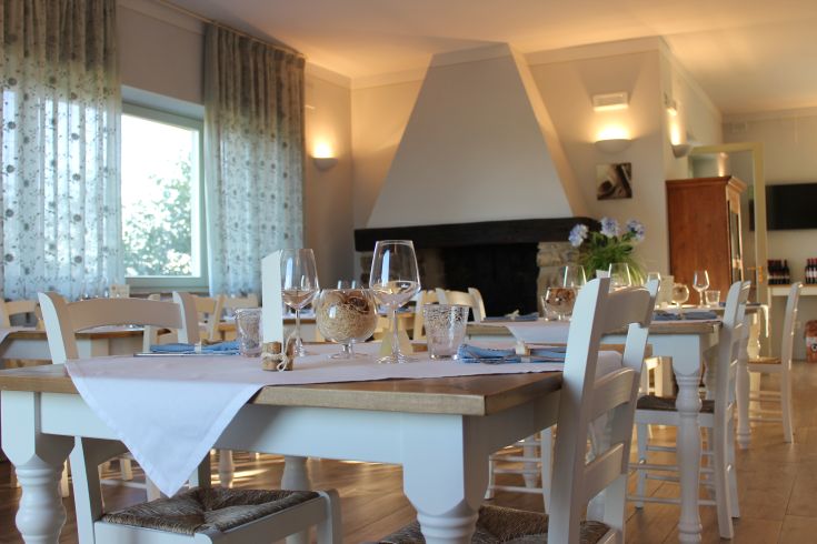 Interior of a restaurant with arranged tables and natural lighting creating a pleasant atmosphere.