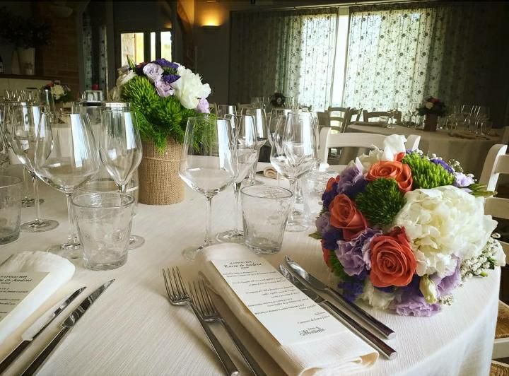 A beautifully set table with simple flowers and cutlery, ready for a convivial lunch.