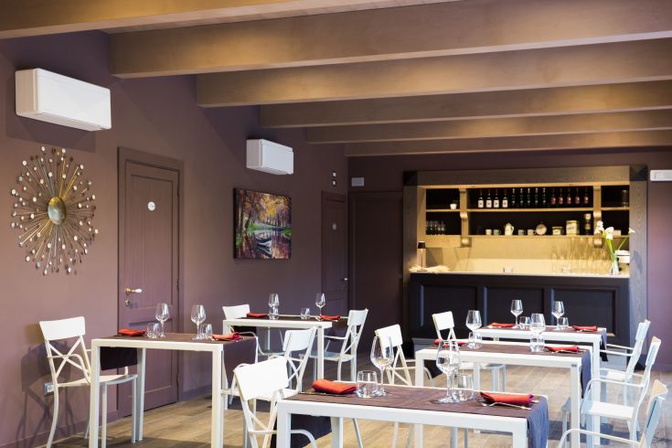 Interior of a cozy restaurant with arranged tables and simple wall decorations.