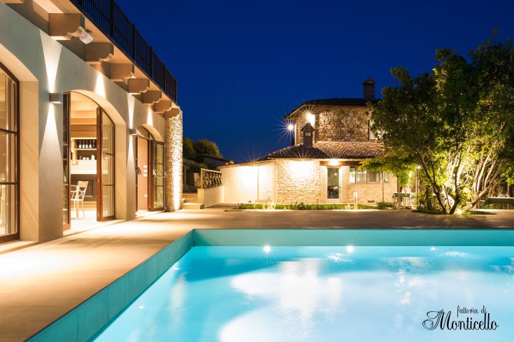 Illuminated pool villa in a well-kept garden, capturing the enchanting night atmosphere.