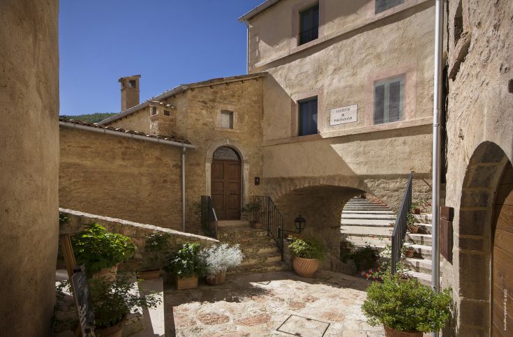 Panorama of Postignano Castle, a well-preserved medieval village in Umbria with historic buildings.