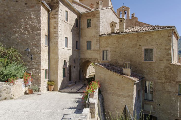 A well-preserved medieval village featuring historic buildings and a serene atmosphere, surrounded by nature.