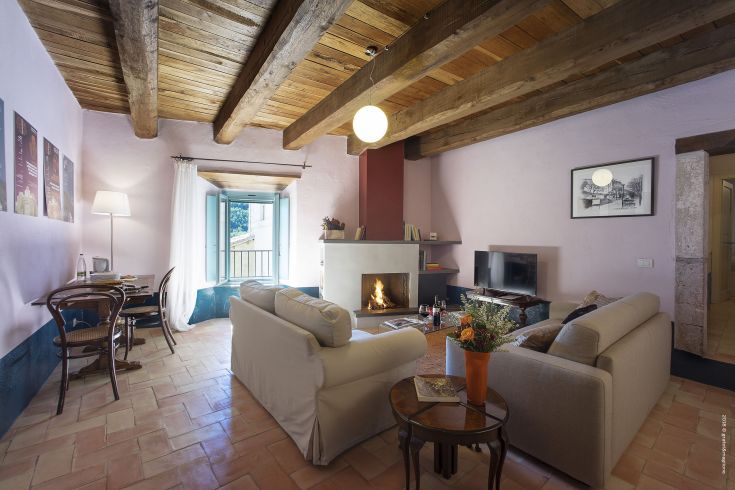Simple living room with terracotta floor and fireplace, perfect for relaxing moments.
