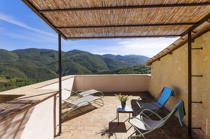 Enjoy relaxing moments on this terrace overlooking the surrounding green hills in a serene atmosphere.
