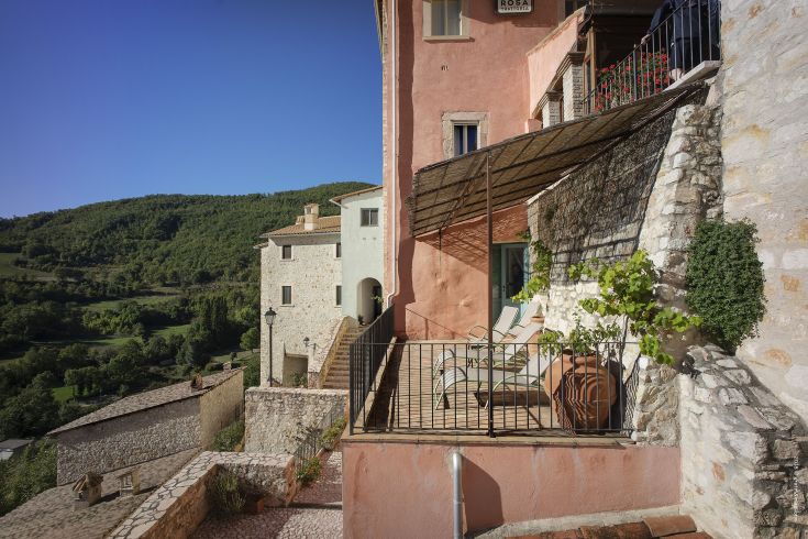 Detail of a palace in a medieval village, surrounded by typical Umbrian vegetation.
