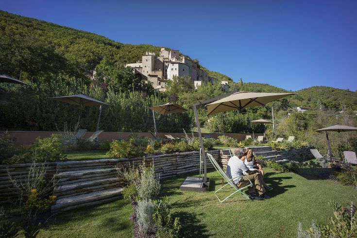 A serene moment surrounded by greenery, amidst the historic walls of the palace located in Postignano.