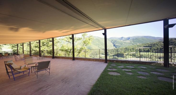 Outdoor terrace for peaceful moments, overlooking the gentle Umbrian hills near a palace.