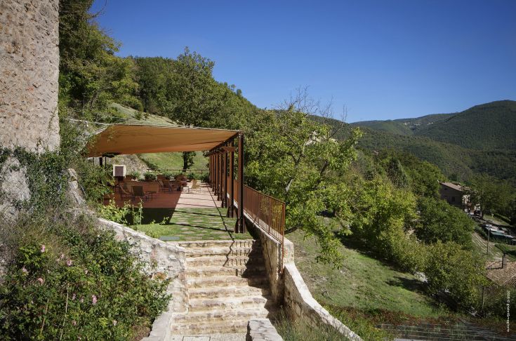 Panorama of Postignano Castle, surrounded by the lush green hills typical of Umbria.